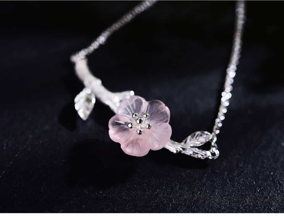 En gros plan, bijou fleur fait de cristal rose avec en son milieu six pistils en argentés 