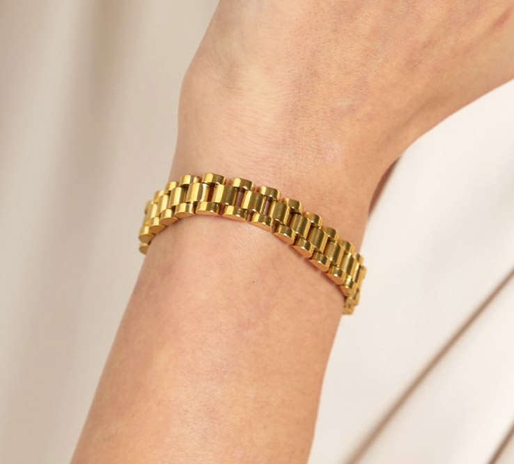 Bracelet or à maillons porté au poignet d'une femme