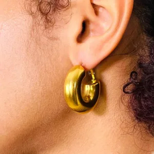 Femme portant à l'oreille gauche une créole épaisse plaque or