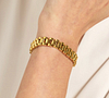Bracelet or à maillons porté au poignet d'une femme