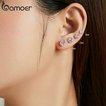 Visage femme portant 4 clous d'oreilles de zircon