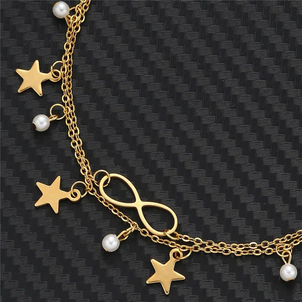 Gros plan d'une partie d'un bracelet breloque avec petites étoiles et perles et bijou infini