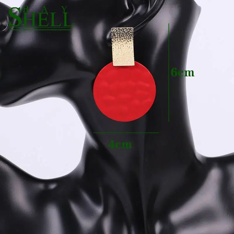 Boucles d'oreilles rouge sur mannequin en plastique noir